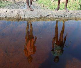 Reflection of two people on the surface of water in South Sudan