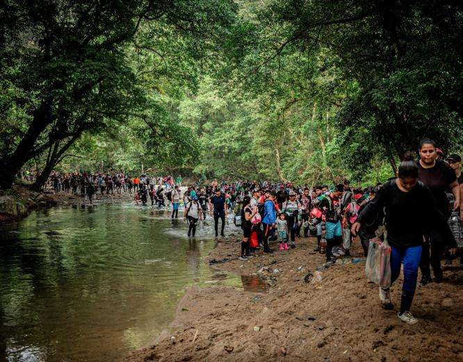 Migrants cross the Acandí and Tuquesa rivers on their way through the jungle of the Darién Gap.
