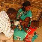 A child is examined by a nurse in the small village of Sortoni, Darfur.